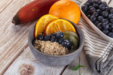 Oats porridge with blueberry, kiwi and orange