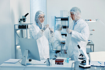 Scientists working with reagents and blood samples in laboratory