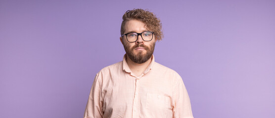 Obraz premium Banner portrait man standing confidently against violet background, copy space. Individuality, modern masculinity, and quiet self-assurance in contemporary portraiture.