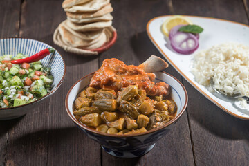 Stew Okra With meat Bamia served with rice, pita bread and salad isolated on wooden table side view of gourmet Middle Eastern stew