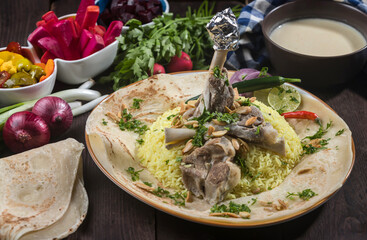 Jordanian Mansaf Arabic Meat rice served on pita bread isolated on wooden table side view of...