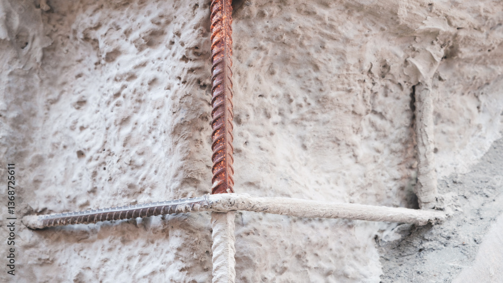Leinwandbilder a wall of a house with a metal reinforcement rod sticking out of it. rod is bent and twisted. wall i