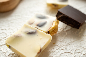 white milk chocolate, dark chocolate and dates on blue background in close-up