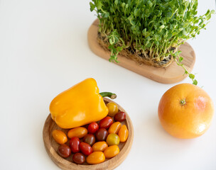 Bright culinary ingredients, vegetables and microgreens are laid out on the table near the wooden...