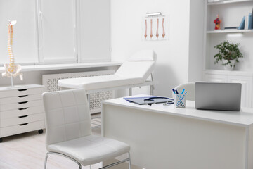 Laptop, stethoscope and folders on desk in medical office