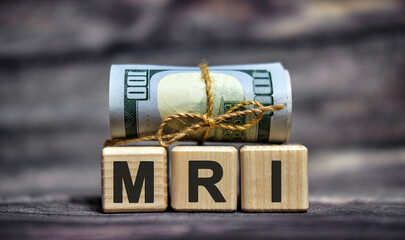 MRI - text on wooden cubes with dollars 100 bills