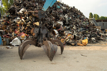 Large tracked excavator working a steel pile at a metal recycle yard. Industrial scrap metal...