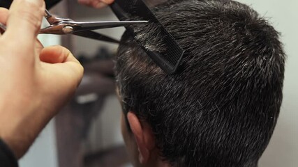 A skilled hairdresser showcases precise haircutting skills at a nearby barbershop. Watch as techniques, tools, and styles come together for a fresh look