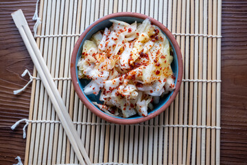 kimchi in fresh white bowl close-up on gray background	