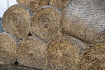 Hay and animal feed in bales in an open warehouse.