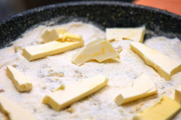 homemade raw apple pie in a baking dish, topped with generous chunks of butter, ready for baking. The pie features a flaky crust and fresh apple filling, perfect for dessert