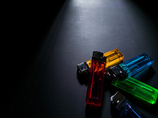 colorful cigarette gas lighters on black