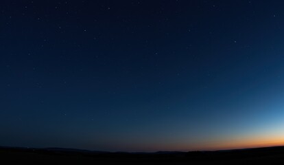 Starry sky at twilight in rural area showcasing a panoramic view of celestial bodies and serene atmosphere.