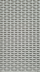 Close-up of woven plastic surface of laundry basket. Close-up of synthetic plastic pattern. Close-up of woven surfaces of plastic household baskets. Texture. Plastic rattan with symmetrical pattern