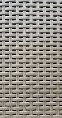 Close-up of woven plastic surface of laundry basket. Close-up of synthetic plastic pattern. Close-up of woven surfaces of plastic household baskets. Texture. Plastic rattan with symmetrical pattern