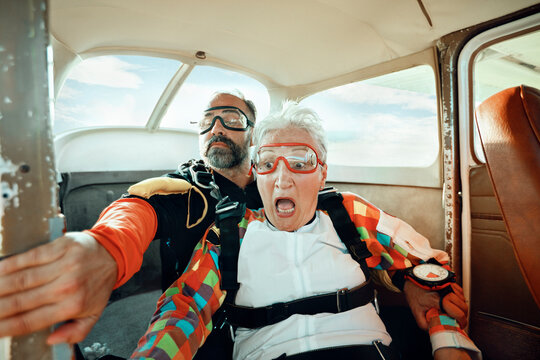 Senior woman skydiver getting ready to skydive with her instructor in a plane