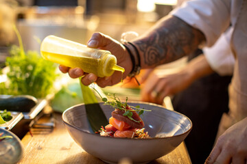Male asian chef preparing a traditional food dish in a restaurant kitchen