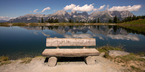 Scenic Wooden Bench at Astberg Lake with Stunning Wilder Kaiser Mountain Reflection, Tyrol, Austria
