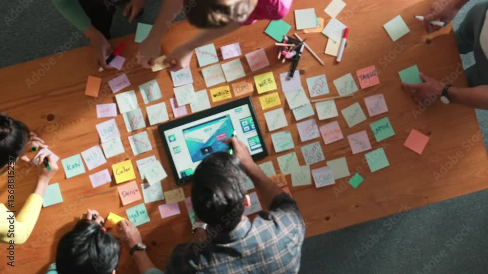 Poster top down view of programmer brainstorming and planning about web design while looking at tablet wire