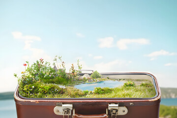 miniature landscape emerging from vintage leather suitcase, surreal travel concept 
