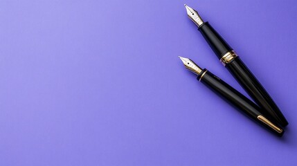 Two elegant, black pens with gold accents rest on a solid purple background