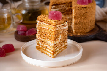Sweet dessert for breakfast: homemade honey cake. A piece of honey cake on a white plate. Close-up