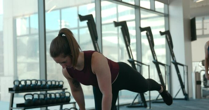 Athletic women perform a hamstring workout during a cross training class