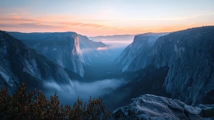 Obraz premium Misty valley sunrise with towering cliffs and vibrant sky - serene landscape