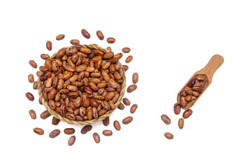 A wicker bowl filled with kidney beans, accompanied by a wooden spoon, surrounded by kidney beans.