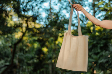 hand holding raw cotton ecobag without print nature background
