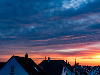 Abendhimmel nach Sonnenuntergang über den Dächern einer Kleinstadt