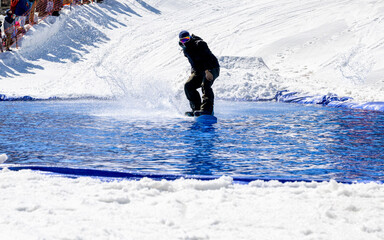 People are enjoying Pond skim at the end of ski season	
