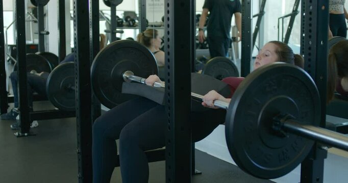 Woman performs a glute bridge workout during a cross fit class