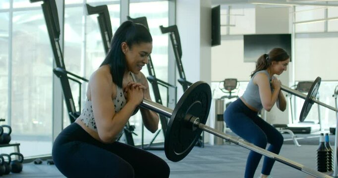 Athletic women perform weighted leg workouts in a gym setting