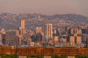 Panoramic view of Beirut, Lebanon, showcasing downtown and districts Dekwaneh, Mansourieh, Daychouniyeh, and Sabtiyeh with an urban skyline.
