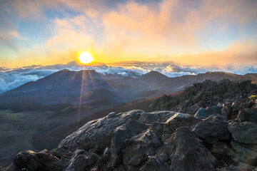 Sunrise landscape at Haleakala vulcano with orange lighting on upper clouds, Maui , Hawaii.