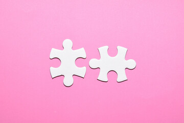 Piezas de puzzle blanca en un fondo rosa, concepto de conexion. 