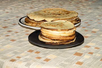 Pancakes of two sizes stacked on plates