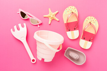 Children's flip flops and beach toys on color background,,top view