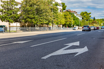 Obraz premium Urban street scene with traffic and road markings in Podgorica, Montenegro on a sunny day