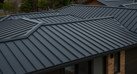 Architectural detail of charcoal gray standing seam roof modern residence