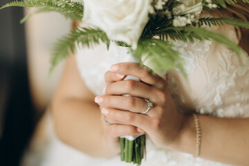 Beautiful bride holds white bouquet.