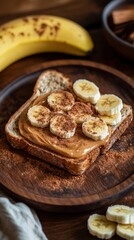 Sliced banana on peanut butter toast with cocoa powder on wooden plate