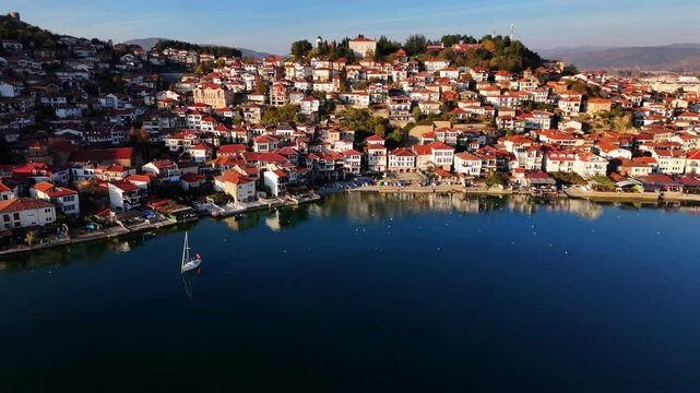 Tranquil drone shot flying over Lake Ohrid, showcasing the Old Town during golden hour