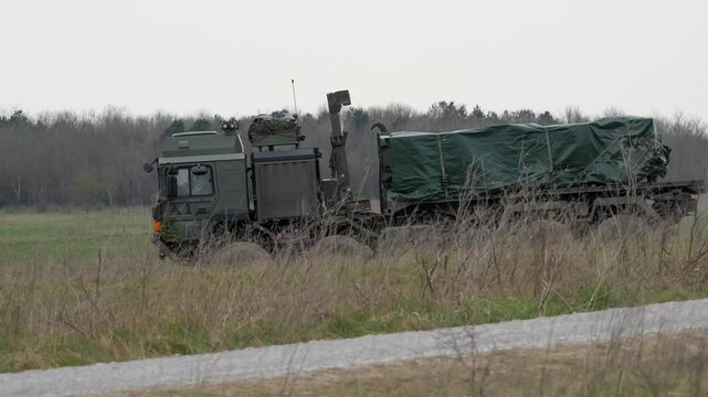 British army MAN EPLS 8x8 logistic truck carrying supplies across countryside