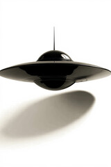 Intriguing black saucer shaped UFO floats against a stark white backdrop creating a minimalist aura