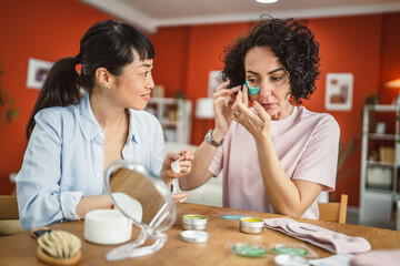 female friends share skincare moment use eye patches relax together