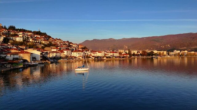 Flying over Lake Ohrid towards the Old Town of Ohrid with a sailboat in the water