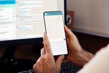 Man showing a phone in his hand and chatting app on the screen of smartphone. Communication Technology, application.