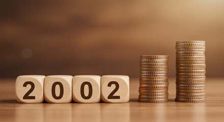 The year 2002 represented by wooden blocks, showcasing the growth of money with two increasing stacks of coins on a warm wooden surface.